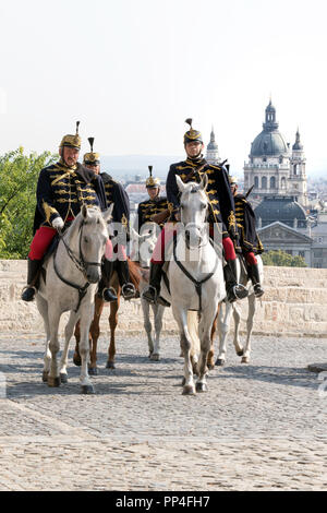 Ussari ungheresi a cavallo su dovere a Budapest la Collina del Castello con dalla Basilica di Santo Stefano, in background Foto Stock