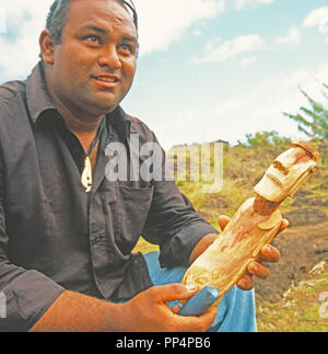 Rapa Nui artista carving Moai in legno per souvenir turistici. Foto Stock