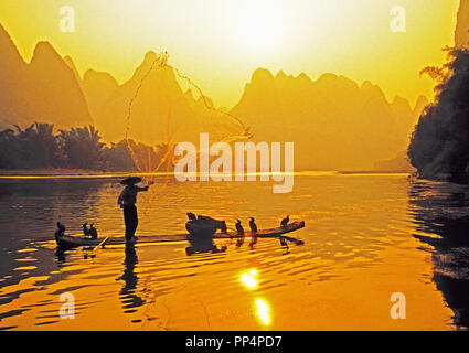 Nel Guangxi, Cina: pescatore sulla zattera di bambù tossing net sul Fiume Li vicino Xingping Foto Stock