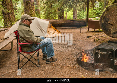 Adulti Senior in un momento di relax a fuoco nella foresta pluviale, Sol Duc campeggio, il Parco Nazionale di Olympic, nello stato di Washington, USA Foto Stock