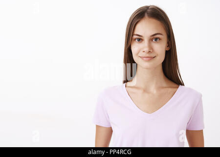 Cordiale affascinante caucasica brunetee femmina con i capelli lunghi e pulire la pelle sana sorridente con gentile e simpatico espressione fiduciosi nel potere proprio mentre partecipa al concorso Foto Stock