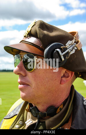 Seconda Guerra Mondiale Army US Air Force pilota del bombardiere re-enactor con la riflessione di Boeing B-17 Flying Fortress bomber piano riflettente in occhiali da sole Foto Stock