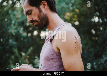 Ritratto di uomo con Kambo cerimonia segna la masterizzazione sul suo braccio Foto Stock