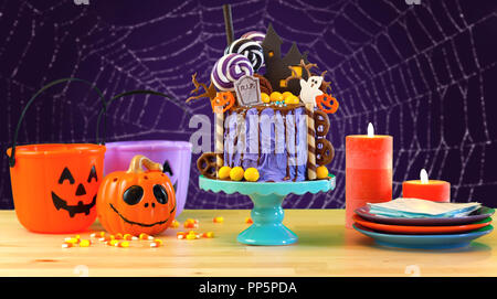 In tendenza Halloween candyland fantasy novità torta di gocciolamento in tema di porpora viola colorati spiderweb parte messa in tavola. Foto Stock