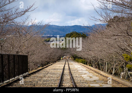 KYOTO, Giappone - 08 FEB 2018: Keage inclinare dalla vecchia linea ferroviaria circondato da alberi di ciliegio Foto Stock