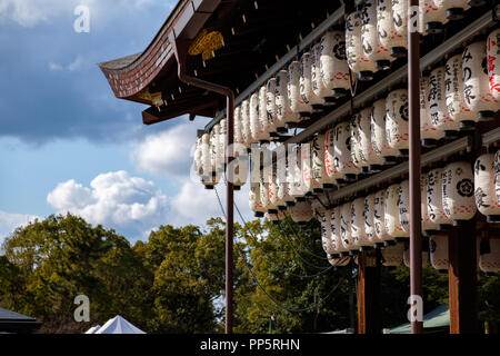 KYOTO, Giappone - 08 FEB 2018: Carta lanterne di luce con il rosso e il nero iscrizioni appesi da un tempio Foto Stock