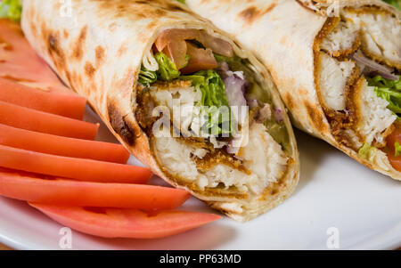 Fritto di pollo dorati in una pita wrap e tagliate a fette Foto Stock