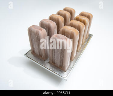 Gelato di caffè per lecca-lecca in stampi di plastica su uno sfondo bianco con spazio per il testo. Dessert estivo Foto Stock