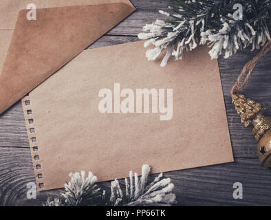 Lettera a Babbo Natale. Foglio di carta bianco con copia spazio su un tavolo di legno circondato da ornamenti natale, vista dall'alto Foto Stock