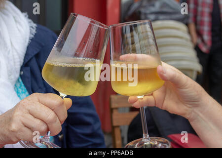 Bicchieri da clinking: Due vecchi amici toccano i loro bicchieri da vino in festa. Foto Stock