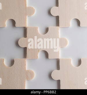 Puzzle su uno sfondo di legno. Concetto business. Idea: il lavoro di squadra. Close up. Foto Stock