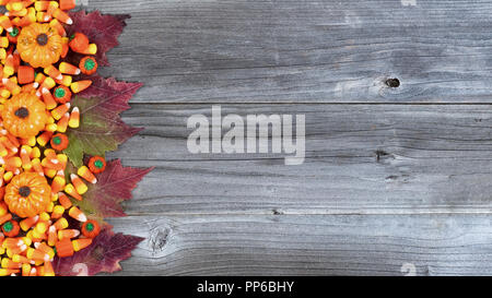 Bordo sinistro di Halloween di caramelle e autunno decorazioni rustiche tavole in legno Foto Stock