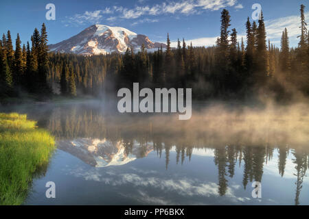Primo bagliore di luce su Washington Mt Rainier dal appropriatamente chiamato laghi di riflessione in Mount Rainier National Park. Foto Stock