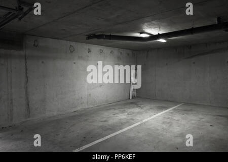 Abstract vuoto parcheggio interno con sfondo grigio scuro pareti in cemento bianco e luci a soffitto Foto Stock