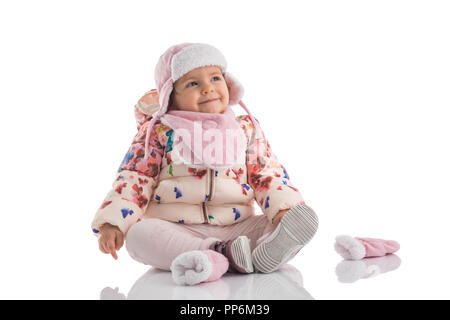 Ritratto di piccolo felice bambina indossa rosa Cappello invernale e soffice coat isolato su sfondo bianco Foto Stock