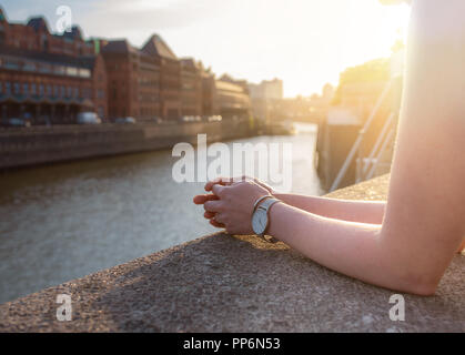 Vista parziale di donna in appoggio le sue braccia sulla parete quay Foto Stock