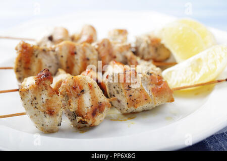 Souvlaki di pollo su spiedini di legno con il limone. DOF poco profondo Foto Stock