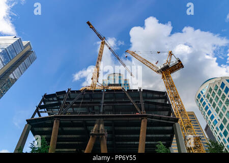 Guardando il sito della costruzione di gru di Skanska 2+U Tower, nuovo grattacielo dietro il 1201 Terza Avenue Tower nel centro di Seattle, WA, U Foto Stock