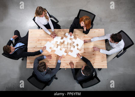 Lavoro di squadra di partner. Concetto di integrazione e di avvio con i pezzi del puzzle Foto Stock