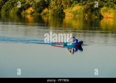 Due uomini che pescano da una piccola barca a remi vicino a Kom Ombo sul fiume Nilo in Egitto Foto Stock