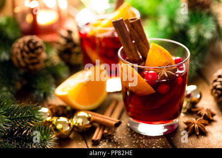 Natale rimuginassero vino rosso con le spezie e le arance in un rustico in legno tavolo. Tradizionale bevanda calda a Natale Foto Stock