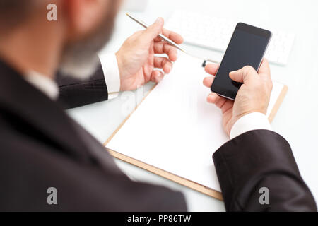 Maschio uomo business utilizzando i moderni smartphone e la scrittura in un blocco note il concetto di business close up Foto Stock