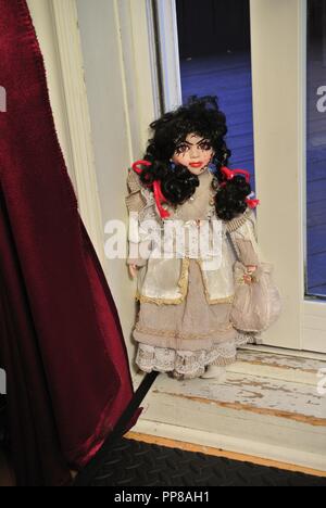 Un creepy porcellana antica bambola con lunghi capelli neri e un pauroso, bella faccia con cicatrici,,vestito in un bianco Vintage dress, venendo voi Halloween Foto Stock