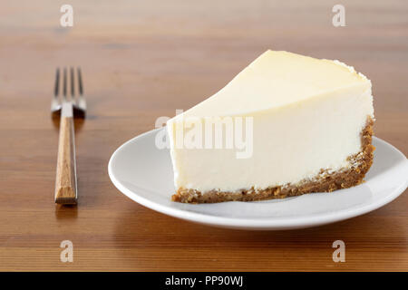 Fetta di pianura New York Cheesecake su un tavolo di legno. Composizione orizzontale Foto Stock