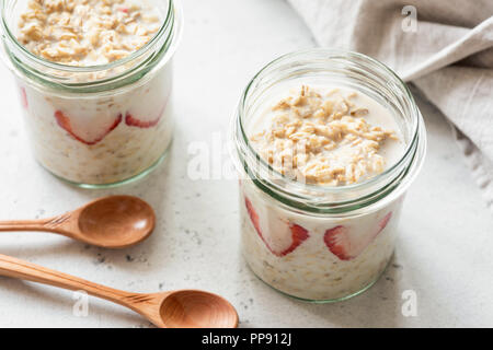 Per una notte di avena o farina di avena in un recipiente su sfondo di calcestruzzo. Mangiare sano, uno stile di vita sano concetto Foto Stock