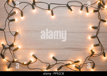 Le luci di Natale la cornice su un legno Foto Stock