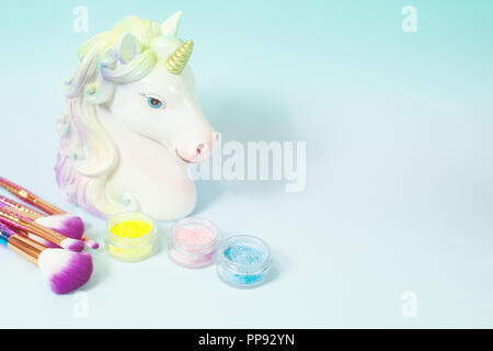 Testa di unicorn e glitter eye ombre su uno sfondo blu. Foto Stock