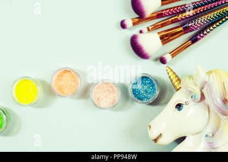 Testa di unicorn e glitter eye ombre su uno sfondo blu. Foto Stock