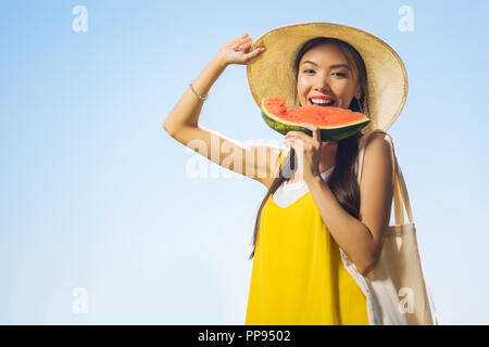 Gioiosa donna felice in possesso di un pezzo di cocomero Foto Stock
