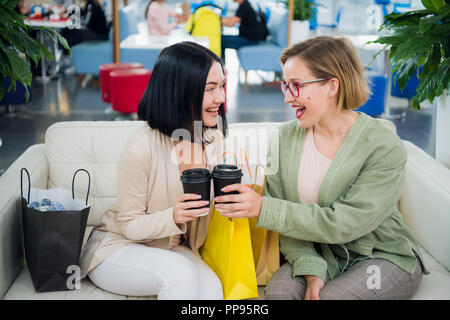 Due giovani donne aventi pausa caffè insieme al centro commerciale per lo shopping Foto Stock