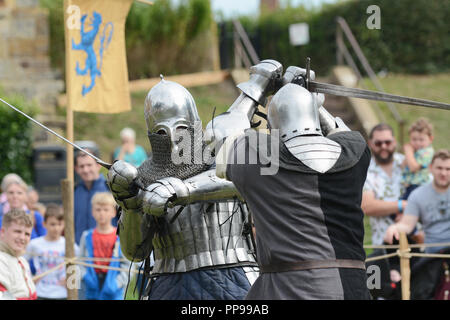 TONBRIDGE, Inghilterra - 9 Settembre 2018: due combattenti di combattimento nel corpo di acciaio le armature e gli elmi spada lotta alla Fiera medievale nella motivazione della Tonbri Foto Stock