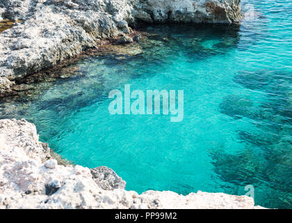 Acqua blu in una grotta rocciosa nei pressi di Ognina, Siracusa, Sicilia, Italia Foto Stock