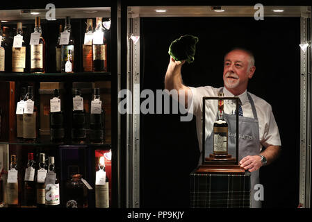 Danny McIlwraith di Bonhams pulisce il gabinetto che ospita il più raest e il più prezioso whisky del mondo - una bottiglia del Macallan Valerio Adami 60 anni 1926 con una stima di &libbra; 700,000-900,000. In vista dell'imminente vendita di whisky Bonhams presso la casa d'aste di Edimburgo, che è destinato a presentare il whisky più raest e prezioso del mondo - una bottiglia del Macallan Valerio Adami 60 anni 1926 con una stima di &libbra;700,000-900,000. Foto Stock