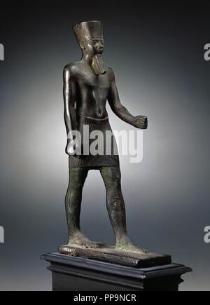 Arte Egizia Statuetta in bronzo raffigurante il dio Amon in piedi con la gamba e il braccio in anticipo e tenendo un scettro ora perdere. Coprire con la sua testa di corona che ha perso due penne, corto mantello e falso barba. Datate tra 664-332 A.C. Abbassare Impero. Museo Archeologico Nazionale. Madrid. Spagna. Foto Stock