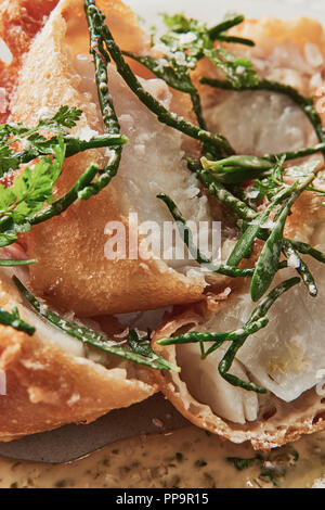 Delizioso merluzzo croccante su piatto bianco con patatine fritte in una ciotola con aceto di malto in polvere nel fresco ristorante londinese del tooting Market fish and chips Foto Stock