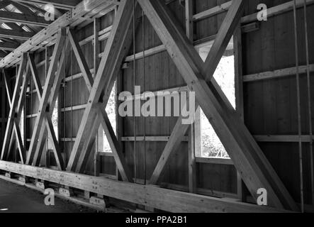 Interno di un ponte coperto in bianco e nero Foto Stock