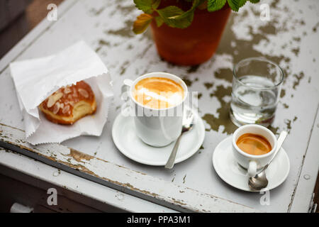 Caffè e ciambelle sulla tavola vintage Foto Stock