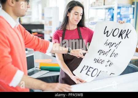 Coworking colleghi con poster stampati Foto Stock