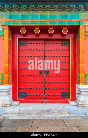 Ornato rosso porta in legno con rivestimento di piastrelle e Chinise tradizionale design presso la Città Proibita, a Pechino, Cina Foto Stock