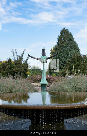 Diva statua accanto alla fontana nel giardino cottage a RHS Wisley Gardens. Surrey, Inghilterra Foto Stock