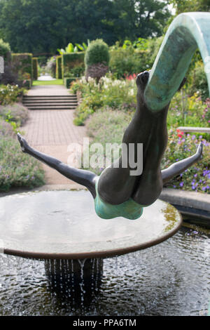 Diva statua accanto alla fontana nel giardino cottage a RHS Wisley Gardens. Surrey, Inghilterra Foto Stock