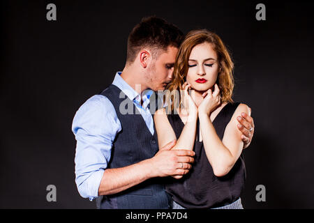 Giovane uomo sorrowly tenendo la donna nelle sue braccia Foto Stock