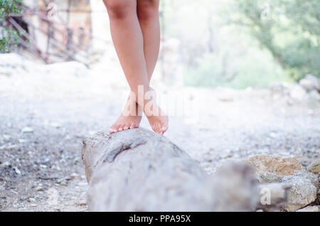 Hippies ragazza in piedi zampe trasversale su un moncone di grandi dimensioni Foto Stock