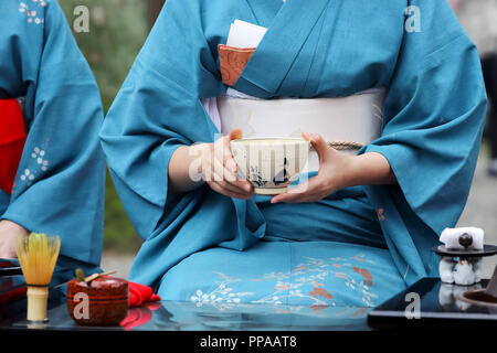 Donna Giapponese in kimono tradizionali di preparazione di tè verdi giapponesi cerimonia al giardino Foto Stock