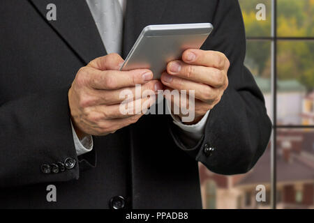 Chiudere l uomo d affari per leggere le notizie sullo smartphone. Foto Stock