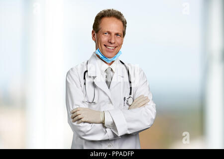 Medico sorridente con ams incrociate. Foto Stock